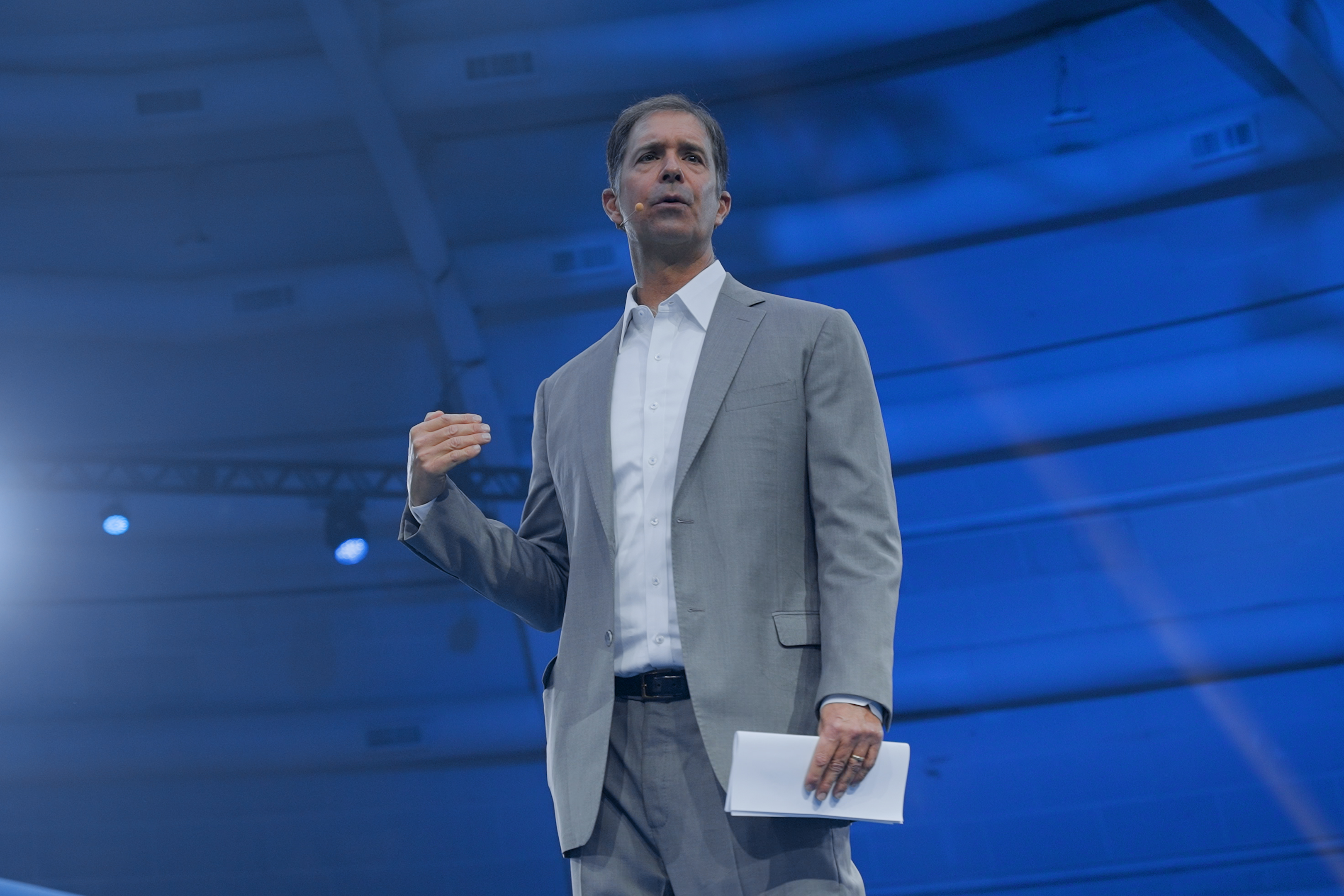 Cam Marston speaking on stage to a live audience
